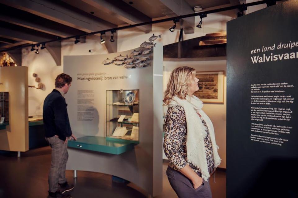 Man en vrouw kijken naar tekst op een wand in een museum